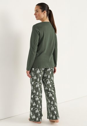 Grön långärmad topp med rundad halsringning, matchad med vida pyjamasbyxor med ett mönster av vita skogsdjur och träd.