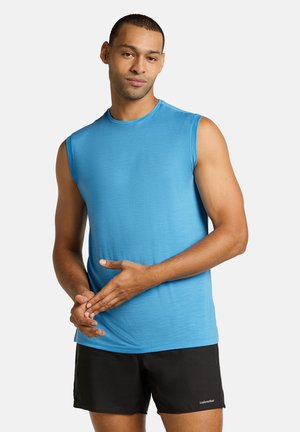 Ärmlös blå träningsskjorta i ett följsamt tyg, med rund hals och en åtsittande design, tillsammans med svarta shorts.