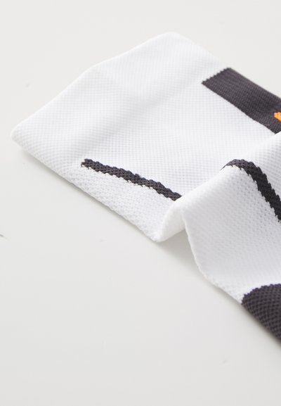 White textile with a textured surface, featuring dark gray and orange accents, folded with a visible black stitching detail.