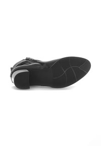 Bottine noire en cuir avec un bout arrondi, fermeture éclair sur le côté et un talon bloc de hauteur moyenne. La semelle en caoutchouc texturé présente des motifs de traction.