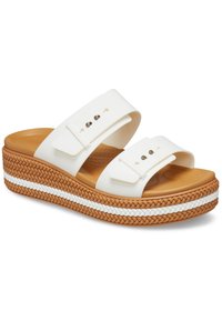 Witte platform sandalen van rubber met twee brede banden, een tan kleurige zool en een gevlochten zijdetail met witte en tan strepen.