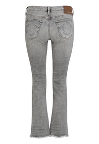 Jean gris évasé avec un ourlet effiloché, doté de deux poches arrière avec des coutures distinctives et d'une étiquette marron au niveau de la taille.