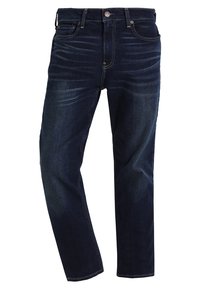 Tmavě modré džíny z denimu se rovnou siluetou, viditelným švem, designem s pěti kapsami a kovovým zapínáním. Lehce vyšisované na stehnech.