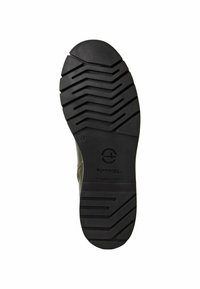 Soletta di scarpa in gomma nera con un motivo di battistrada multidirezionale e un logo circolare. Presenta una punta liscia e arrotondata e bordi rinforzati.