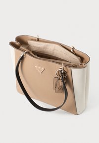 Borsa tote beige e crema con una forma strutturata, materiale testurizzato, hardware dorato, un accento con portachiavi e un scomparto interno con zip.
