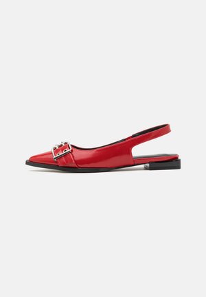 Slingback flat in vernice rossa con punta affusolata, dotata di un dettaglio in fibbia metallica e tacco nero basso.