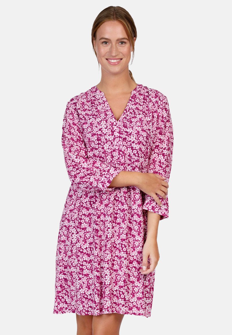 Pink floral dress with a V-neck, three-quarter sleeves, and a loose fit. Features a white flower pattern across a textured fabric.