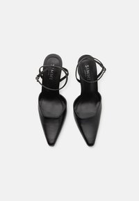 Saltos slingback em couro preto com bico fino e tira no tornozelo, apresentando uma textura suave e design minimalista.