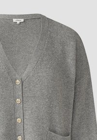 Cardigan grigio in maglia con scollo a V, dotato di cinque bottoni dorati sul davanti e una tasca laterale. Texture morbida e vestibilità rilassata.