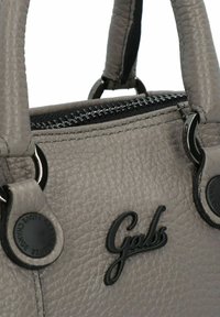 Grijze textured leren handtas met zwarte hardware en logo-accenten, voorzien van een ritssluiting en dubbele handvatten aan de bovenkant.