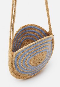 Rund halmväsk i naturliga och blå färger, med koncentriska cirkelmönster, en flätad rem och texturerade vävdetaljer.