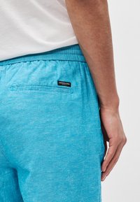 Ανοιχτό μπλε, υφαντό σορτς με ελαστική μέση, που διαθέτει πίσω τσέπη και μια μικρή ετικέτα λογότυπου στην τσέπη.