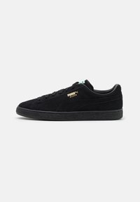 Schwarze Wildledersneaker mit strukturiertem Finish, Schnürdesign und goldenen Puma-Logo an der Seite. Mit einer schwarzen Gummisohle.