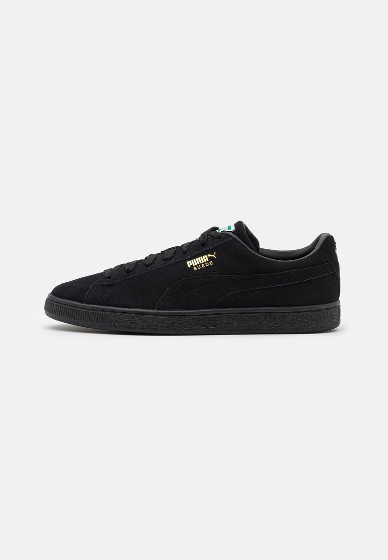 Schwarze Wildledersneaker mit strukturiertem Finish, Schnürdesign und goldenen Puma-Logo an der Seite. Mit einer schwarzen Gummisohle.
