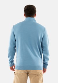 Pullover azzurro chiaro con colletto e maniche lunghe. Realizzato in tessuto morbido, presenta polsini e orlo a costine. Visualizzazione dalla parte posteriore.