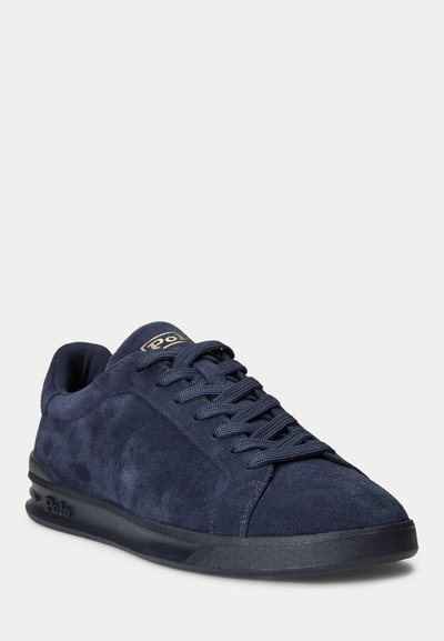 Baskets en daim bleu marine avec semelle noire, lacets assortis bleu marine et marquage "Polo" sur la languette et le côté près du talon.