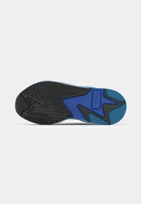 A sola do sapato apresenta uma base de borracha preta texturizada com destaques em azul e ranhuras para tração; inclui um logótipo e padrões para aderência.