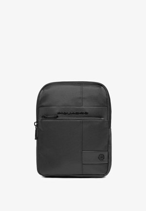 Bolso bandolera compacto negro con bolsillo delantero con cremallera, tejido texturizado y una pequeña placa con el logo en la esquina inferior derecha.