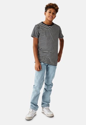 Raidallinen t-paita harmaana ja tummansinisenä, pyöreällä pääntiellä, yhdistetty vaaleansinisiin farkkuihin ja valkoisiin lenkkareihin. Rentoon tyyliin, väljä istuvuus ja käärityt hihansuut.