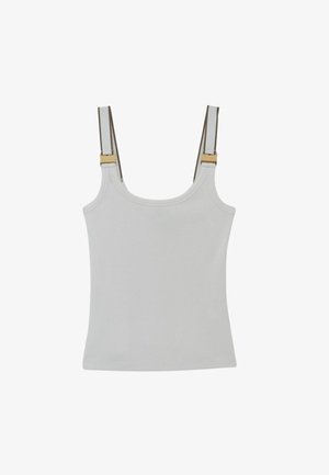 Biały prążkowany top na ramiączkach z regulowanymi beżowymi paskami i złotymi klamrami na jednolitym tle.