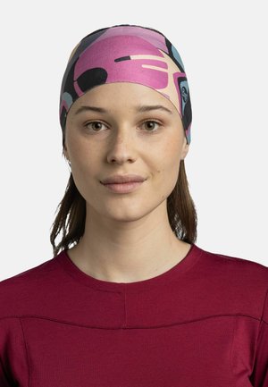 Headband featuring an abstract pattern in pink, black, and blue, made of stretchy fabric, worn by a person with shoulder-length hair.