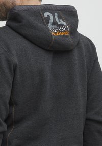 Dark gray hoodie with a textured fabric, featuring orange stitching and a graphic print on the back showing "24" and "Authentic."