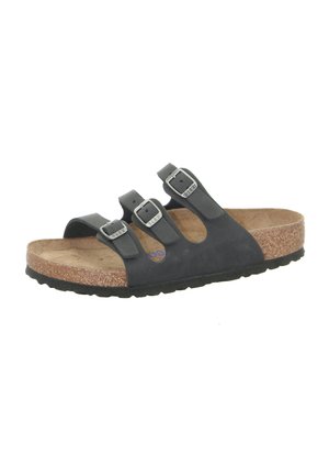 Black leather sandal with three adjustable buckles, cork footbed, and textured rubber sole. Open design with rounded toe and contoured shape.