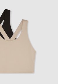 Top sportivo bifacciale in tessuto morbido e elasticizzato beige e nero. Design incrociato con una texture liscia e senza elementi hardware visibili.