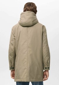 Parka beige con capucha, con un corte recto, puños abotonados y una textura suave. La vista trasera destaca las costuras y el diseño minimalista.