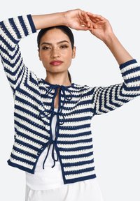 Navy and white striped cardigan with tie closure, featuring open-knit details, three-quarter sleeves, and a cropped silhouette.