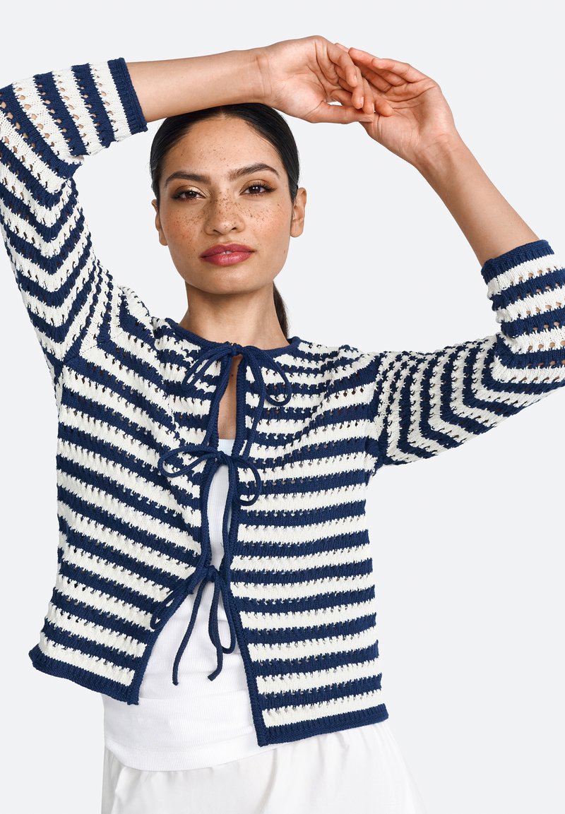 Navy and white striped cardigan with tie closure, featuring open-knit details, three-quarter sleeves, and a cropped silhouette.