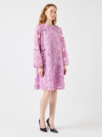 Purple floral lace dress with long sheer sleeves and a mandarin collar, featuring textured flower patterns and a loose fit. Black high heels.