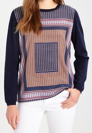 Langærmet navyblå overdel med geometrisk mønstret front i navy, orange og hvide nuancer. Rund hals og afslappet pasform, materiale af bomuldsblanding.