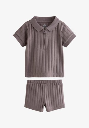 Polo majica kratkih rukava s rebrastim uzorkom, patent zatvaračem i odgovarajućim elastičnim rebrastim šortsevima u prigušenoj smeđoj boji.