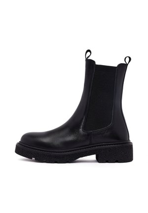 Bottines en cuir noir avec des panneaux latéraux en élastique et une semelle texturée et épaisse. Comportent des tirants sur les côtés pour un enfilage facile.