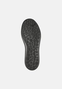 Black rubber shoe sole featuring circular and textured patterns, with the brand "Camper" embossed and size marked as "42."
