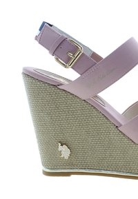 Sandalo con tacco a cuneo rosa caratterizzato da una base in espadrille testurizzata, cinturino con fibbia dorata e un piccolo emblema sul lato. Materiale superiore liscio.