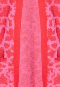 Rosa texturerad tyg med ett gepardtryckmönster på sidorna, som kontrasterar med enfärgade rosa ränder i mitten. Mjukt, plyschigt utseende.