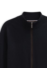 Giacca nera a maglia con zip e colletto alto, dotata di una cerniera marrone e un delicato dettaglio del logo sul petto. Texture liscia.