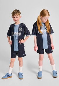 Hummel-Sportbekleidung-Set mit einem marineblau-hellblau gestreiften Trikot mit Logo, passenden Shorts und hellblauen Sportschuhen.