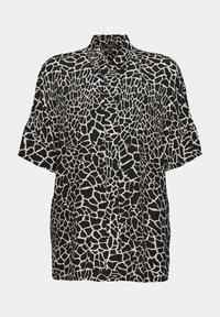Chemise à manches courtes en noir et blanc avec un imprimé girafe, dotée d'un col et d'une coupe ample et décontractée. Texture de tissu douce.