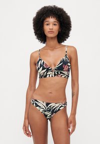 Floral bikini set featuring a black background, triangular bralette with adjustable straps, and matching low-rise bottoms with leaf patterns.