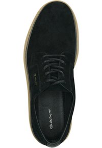 Schwarze Wildleder-Schnürschuhe mit runder Zehenform, gefüttertem Lederfußbett und einer kontrastierenden hellbraunen Gummisohle. Minimalistische Markenkennzeichnung.