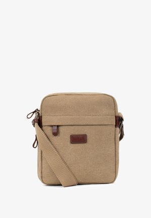 Petit sac bandoulière compact en toile beige avec bandoulière ajustable, poche avant zippée et écusson de marque en cuir marron.