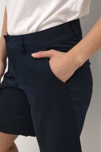 Navy blue shorts featuring a flat front, side pockets, and a smooth, slightly stretchy fabric for comfort.