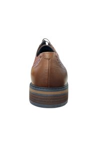Zapato de cuero marrón con forma redondeada, que presenta un acabado texturizado, tacón bajo y suela rayada en contraste. La vista trasera muestra detalles de costura.