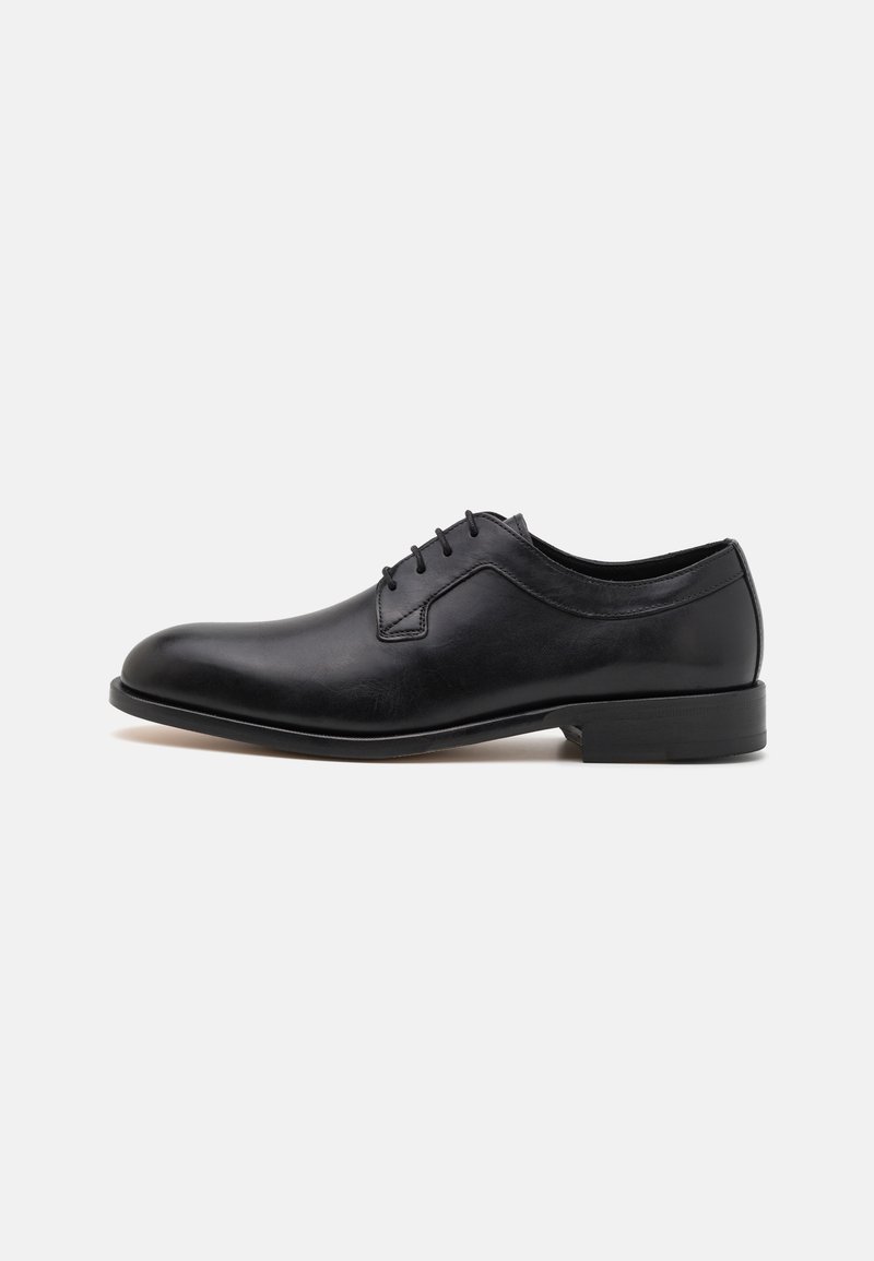 Black leather dress shoe with a smooth finish, rounded toe, six-eyelet lace closure, and a low stacked heel. Minimalist design, no visible patterns.