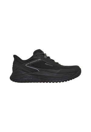 Schwarzer wasserdichter Sportschuh mit Schnürverschluss und dicker profilstarker Sohle, mit Goodyear auf der Sohle gebrandmarkt für dauerhaften Halt.