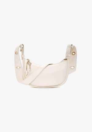 White leather shoulder bag with a curved shape, gold hardware accents, and a decorative charm featuring a leaf and pearl detail.