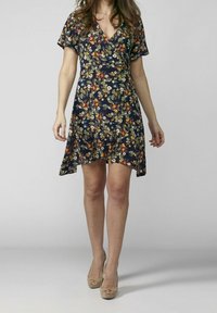 Blommig klänning med djup V-ringning, korta ärmar och A-linjeform. Har en mörk marinblå bakgrund med flerfärgade blommor och gröna blad.